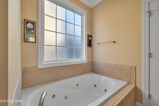 bathroom featuring ornamental molding and tiled tub