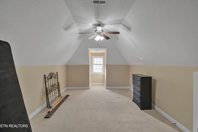 bonus room featuring a textured ceiling, ceiling fan, light carpet, and vaulted ceiling