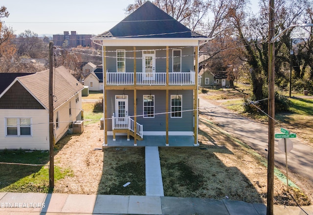 view of front facade featuring a balcony and a front yard