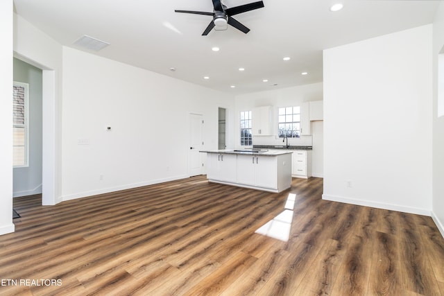 unfurnished living room with dark hardwood / wood-style floors, ceiling fan, and sink