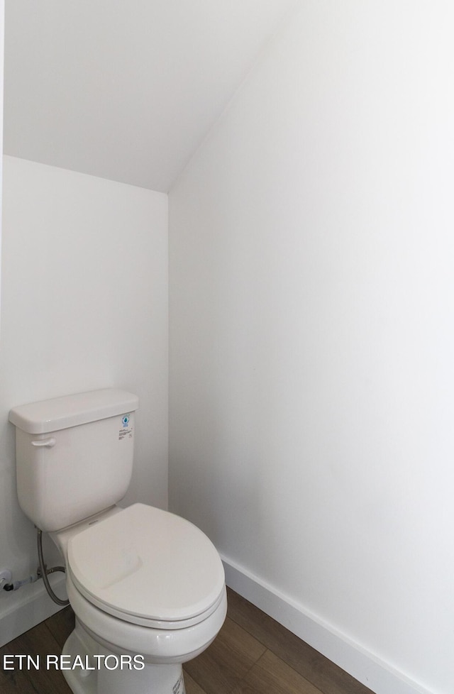 bathroom with hardwood / wood-style flooring and toilet