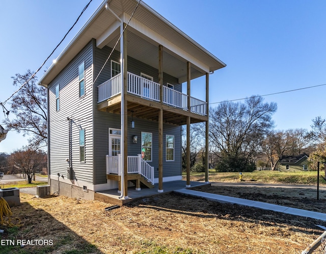 view of front of house with a balcony and central AC