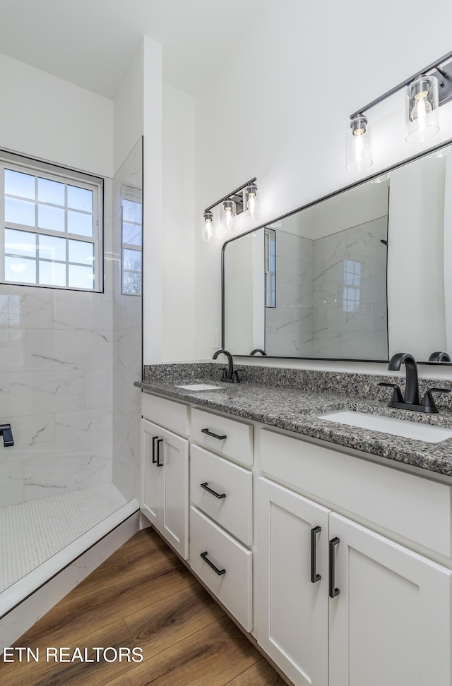 bathroom featuring a tile shower, vanity, and hardwood / wood-style flooring