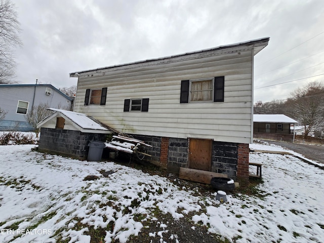 view of snow covered rear of property