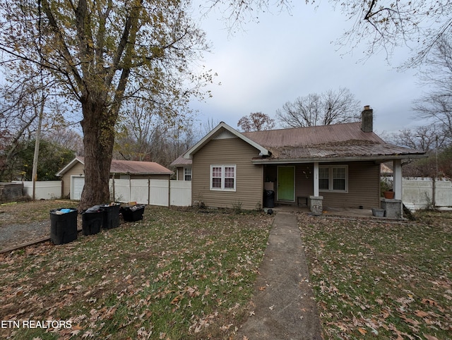 view of front of property with an outdoor structure, a front yard, and a garage