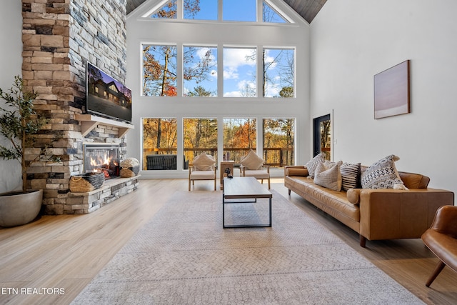 unfurnished living room with hardwood / wood-style flooring, a fireplace, and high vaulted ceiling