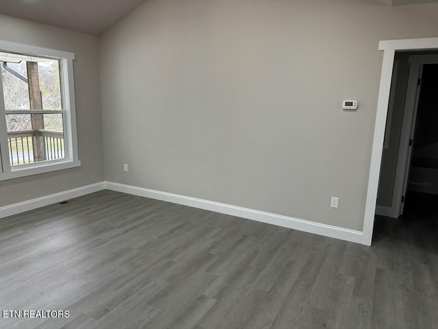 unfurnished room with dark wood-type flooring