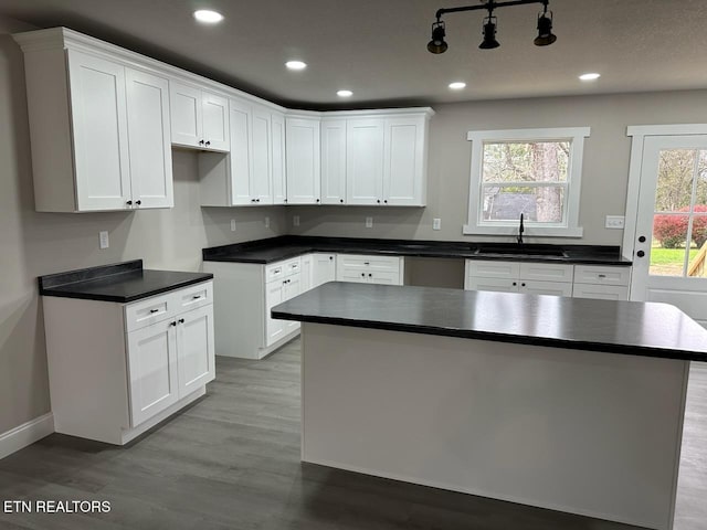 kitchen featuring white cabinetry, plenty of natural light, light wood-type flooring, and sink