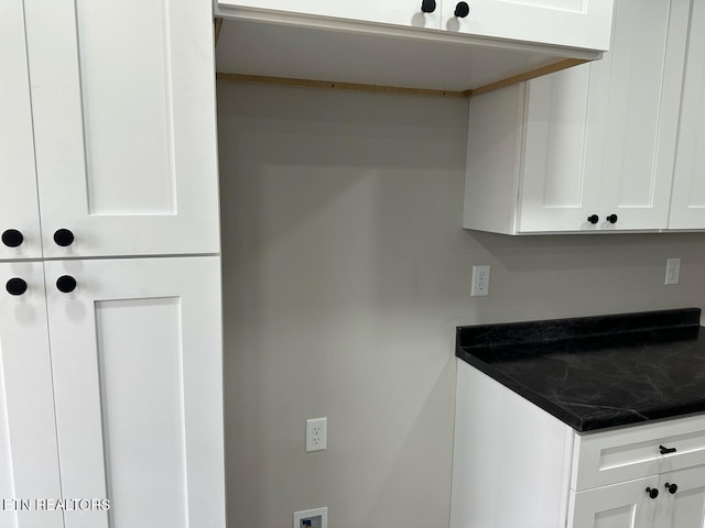 interior space with white cabinets and dark stone counters