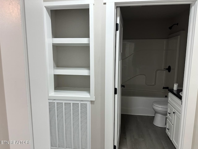 full bathroom with vanity, wood-type flooring,  shower combination, and toilet