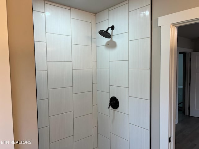 interior details featuring a tile shower