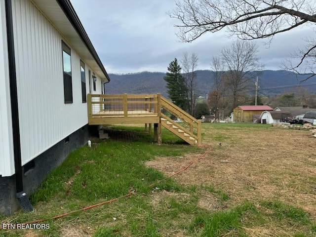 view of yard with a deck with mountain view