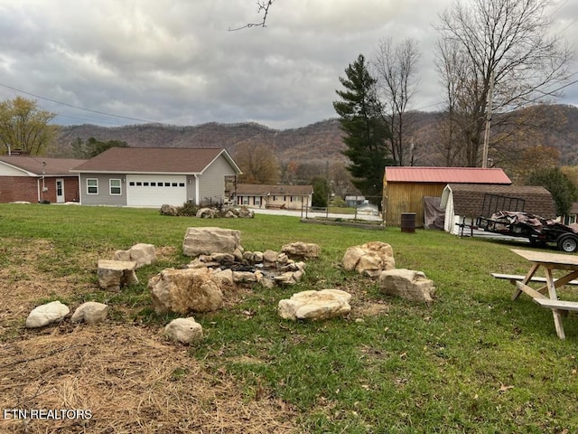 view of yard featuring a mountain view, a garage, and an outdoor structure