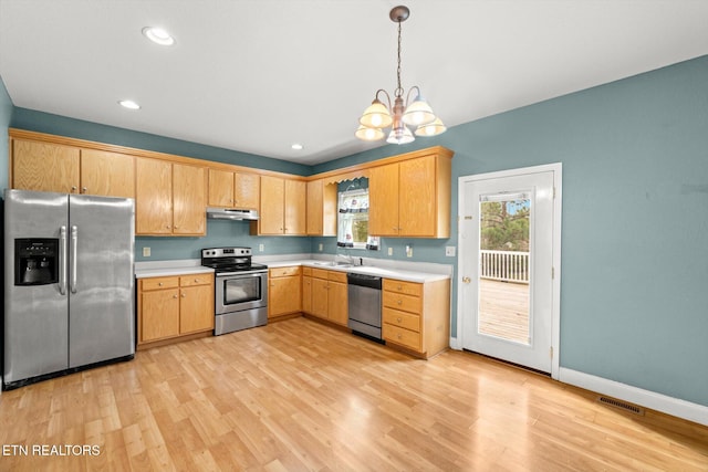 kitchen with a chandelier, light hardwood / wood-style floors, decorative light fixtures, light brown cabinetry, and appliances with stainless steel finishes