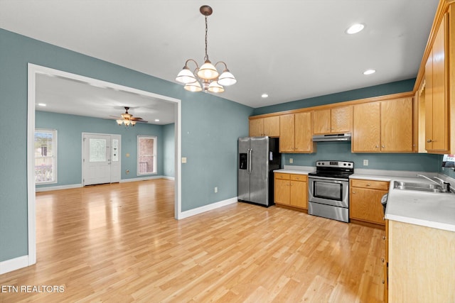 kitchen with sink, stainless steel appliances, light hardwood / wood-style floors, decorative light fixtures, and ceiling fan with notable chandelier