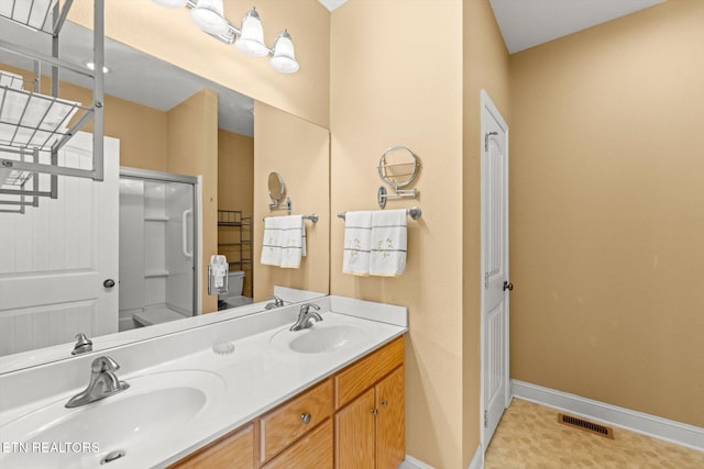 bathroom featuring a shower with door and vanity