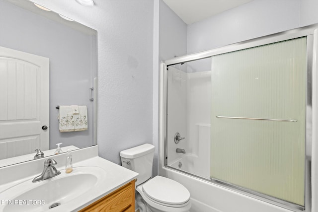 full bathroom featuring combined bath / shower with glass door, vanity, and toilet