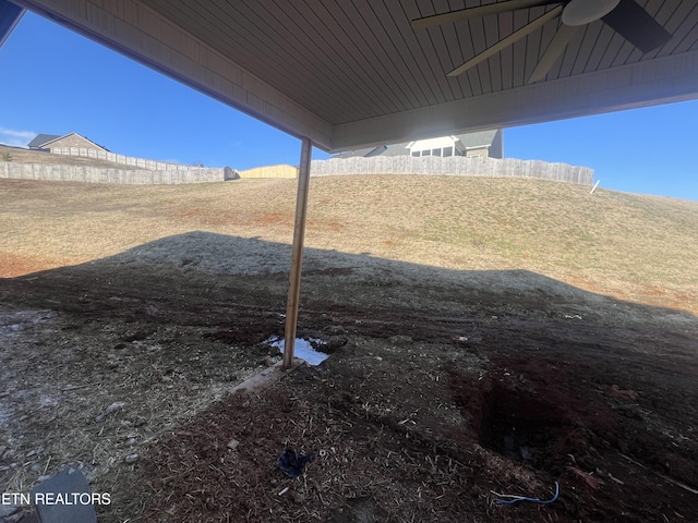 view of yard featuring ceiling fan and fence