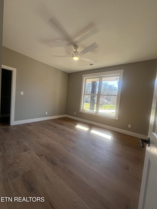 unfurnished room featuring dark wood-style floors, baseboards, and visible vents