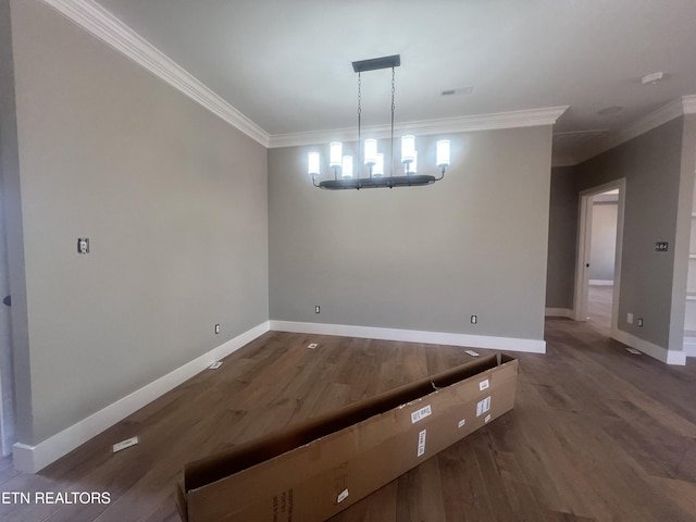 unfurnished dining area with ornamental molding, dark wood finished floors, a notable chandelier, and baseboards