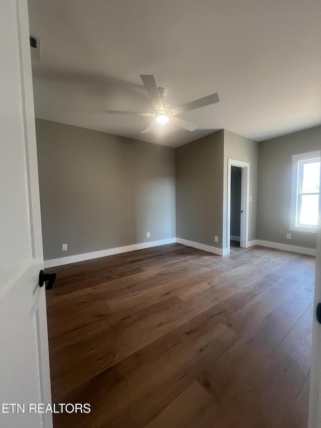 unfurnished room with ceiling fan, wood finished floors, and baseboards