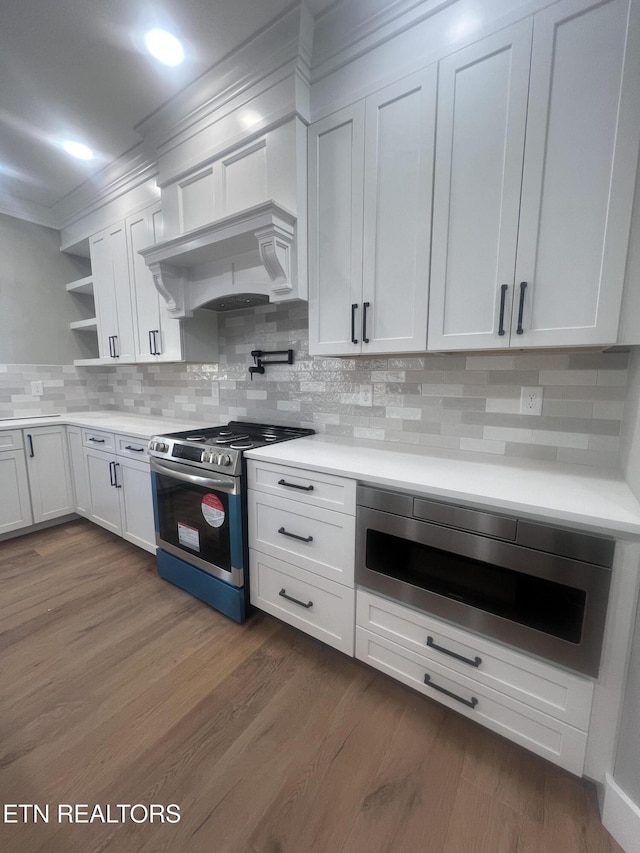 kitchen featuring white cabinets, dark wood-style flooring, stainless steel appliances, light countertops, and open shelves