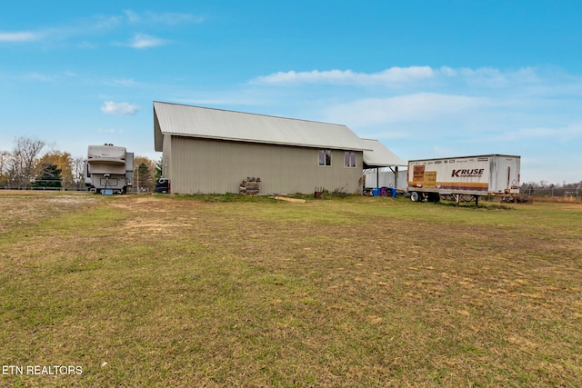 back of property with an outdoor structure and a lawn