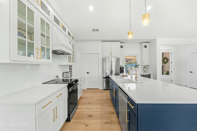 kitchen featuring sink, hanging light fixtures, blue cabinets, white cabinets, and appliances with stainless steel finishes