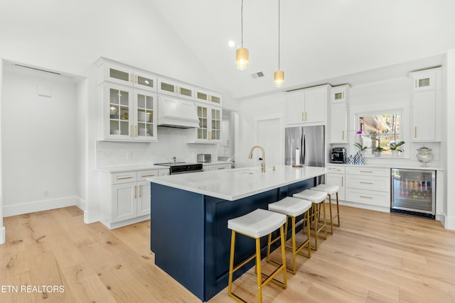 kitchen with stainless steel fridge, premium range hood, beverage cooler, light hardwood / wood-style flooring, and white cabinetry