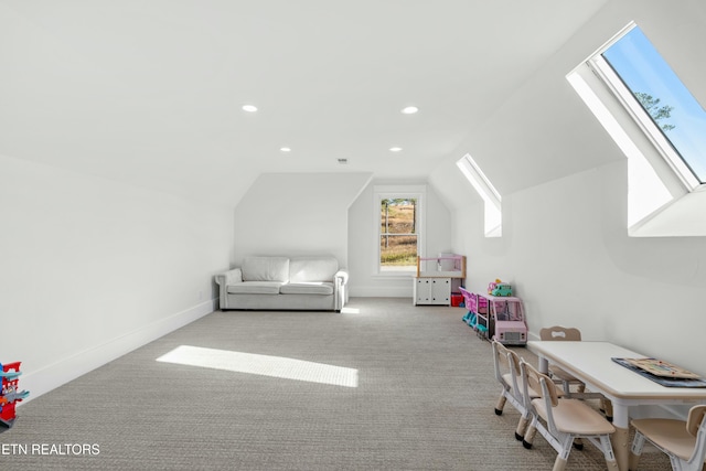 rec room with light colored carpet and lofted ceiling with skylight