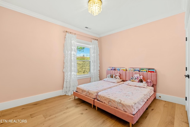 bedroom with hardwood / wood-style flooring and ornamental molding