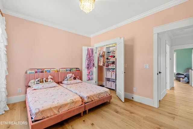 bedroom with hardwood / wood-style floors, crown molding, and a closet