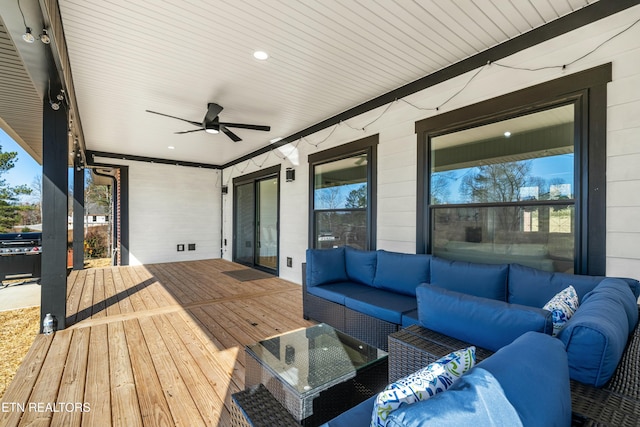 wooden deck with outdoor lounge area and ceiling fan