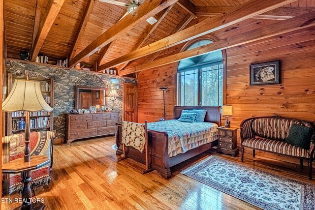 bedroom featuring vaulted ceiling with beams, light wood-type flooring, wooden walls, and wooden ceiling