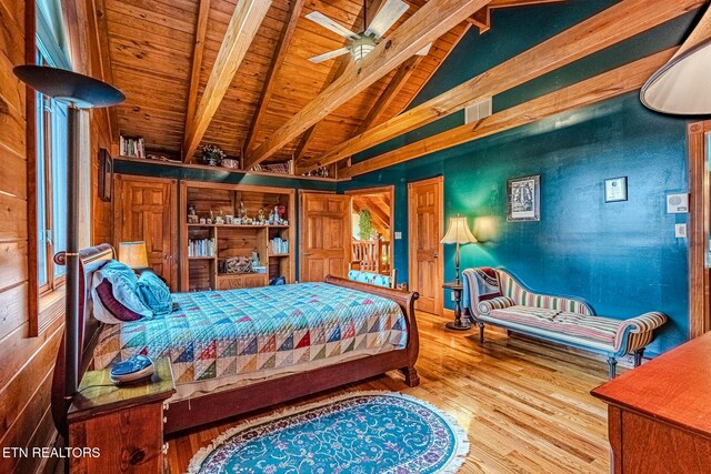 bedroom featuring lofted ceiling with beams, wood walls, wood-type flooring, and wooden ceiling