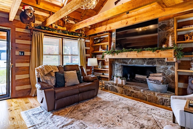 living room featuring hardwood / wood-style flooring, plenty of natural light, a stone fireplace, and wood ceiling