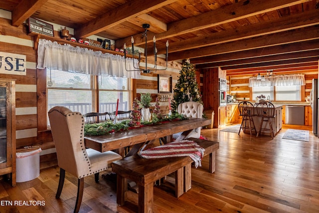 dining space featuring wooden walls, plenty of natural light, wooden ceiling, and hardwood / wood-style flooring