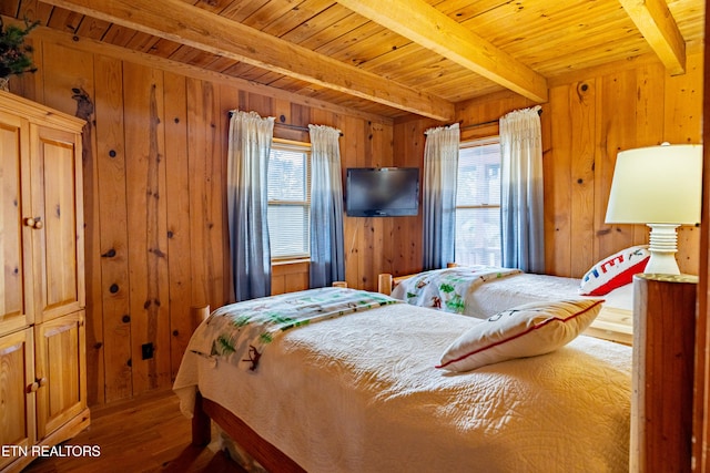 bedroom with multiple windows and wood walls