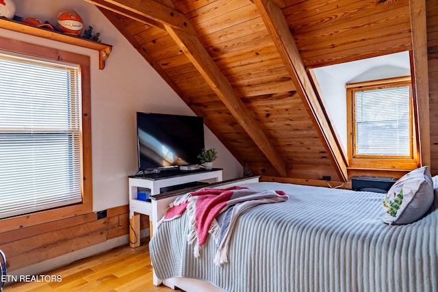 bedroom featuring lofted ceiling with beams, light hardwood / wood-style flooring, and wooden ceiling