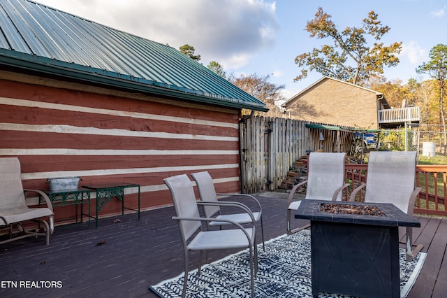 view of patio / terrace with a wooden deck and an outdoor fire pit