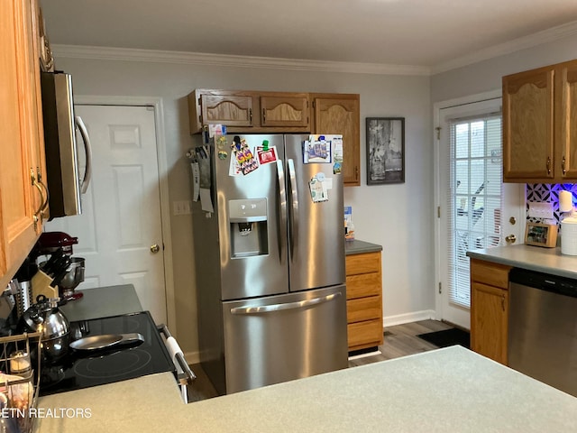 kitchen featuring appliances with stainless steel finishes, dark hardwood / wood-style floors, and ornamental molding