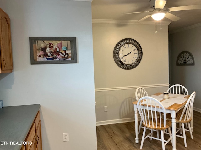 dining room featuring crown molding, ceiling fan, and dark wood-type flooring