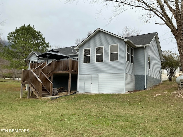 back of house featuring a deck and a lawn