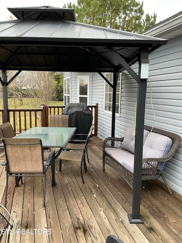 wooden terrace with a gazebo and area for grilling