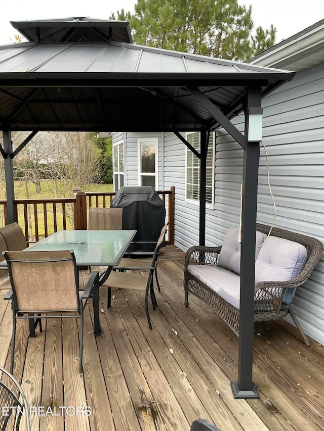 wooden deck with a gazebo and area for grilling