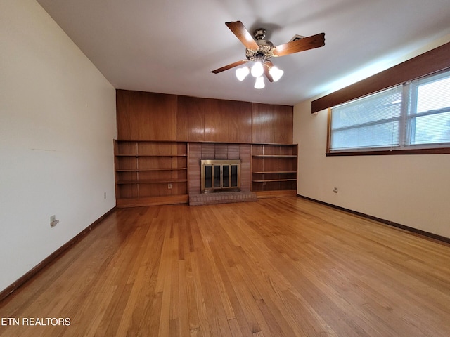 unfurnished living room with ceiling fan, a fireplace, and light hardwood / wood-style flooring