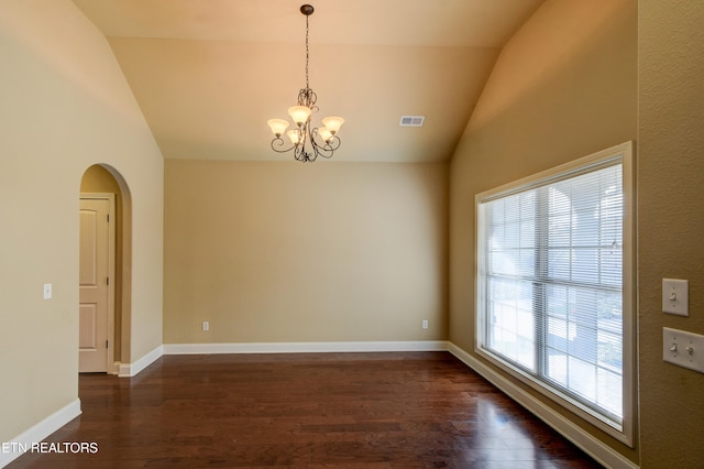 empty room with a chandelier, dark hardwood / wood-style flooring, and lofted ceiling