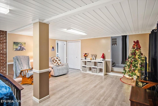 living area with beamed ceiling, wooden ceiling, and light wood-type flooring