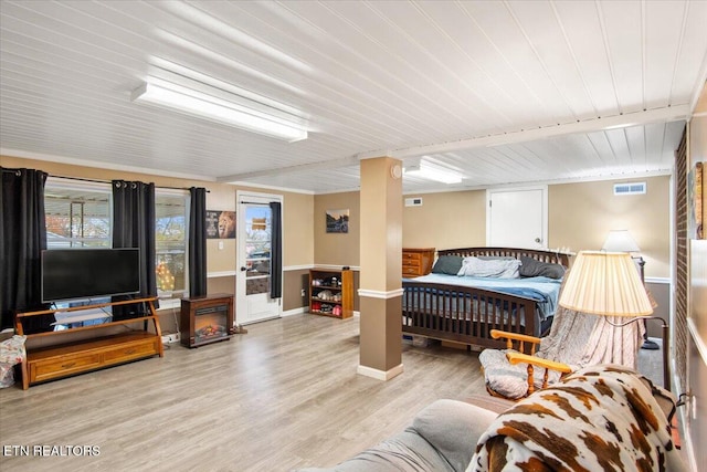 bedroom featuring beamed ceiling, light hardwood / wood-style floors, and wood ceiling