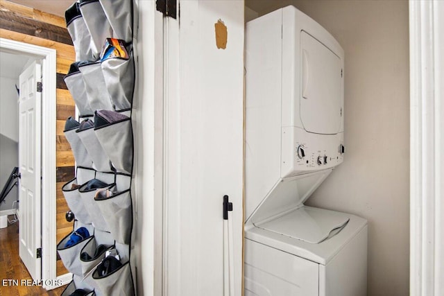 laundry area featuring dark hardwood / wood-style flooring and stacked washer and clothes dryer